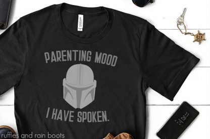 close up of The Mandalorian helmet svg on black t shirt with cut files for parents that read parenting mood I have spoken