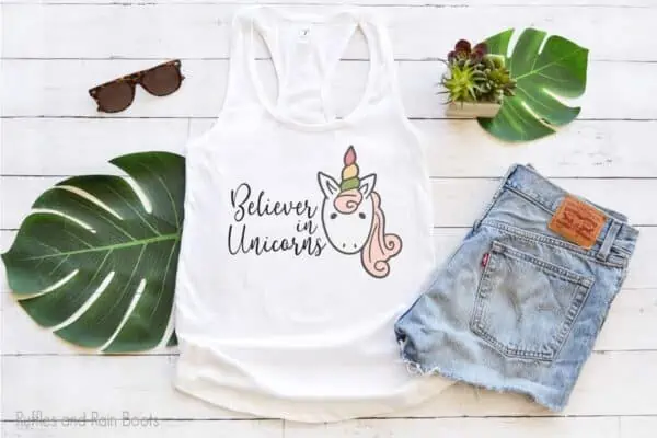 tank top laying on a table featuring Believer in Unicorns sublimation file