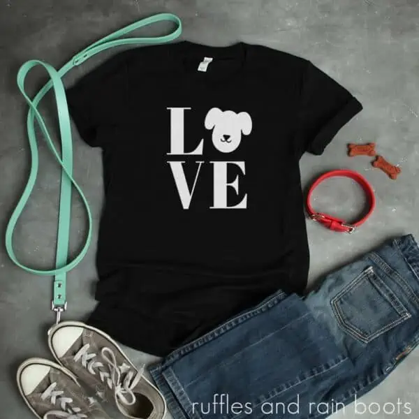 white dog love svg on black t shirt on concrete background with dog leash and collar