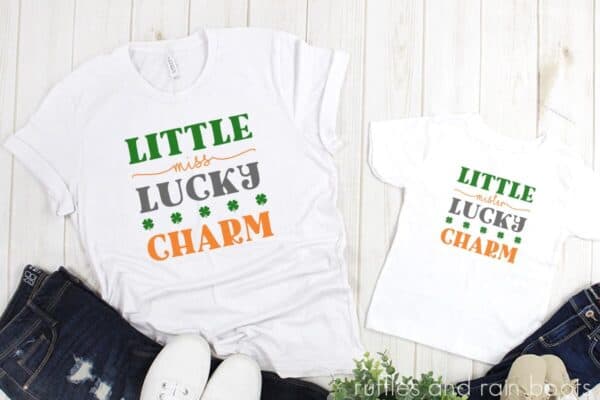 lucky charm svg placed on white t shirts on white wood background as a Cricut project idea for St Patricks Day