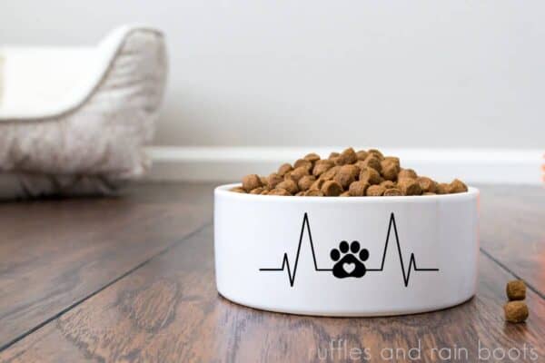 full dog food bowl on wooden floor with a dog paw heartbeat cut file in vinyl