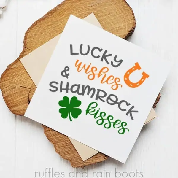 st patricks day card with svg on white card stock stacked on an envelope and wood plank
