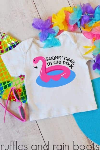 adorable flamingo svg of floatie stayin cool in the pool svg on a tshirt for kids laying on a table with pool toy