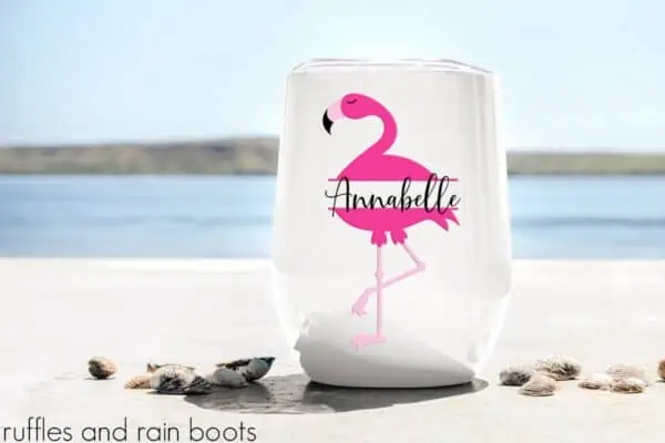 flamingo svg monogram with split monogram style for clipart and cut files on a stemless wine glass sitting on the beach