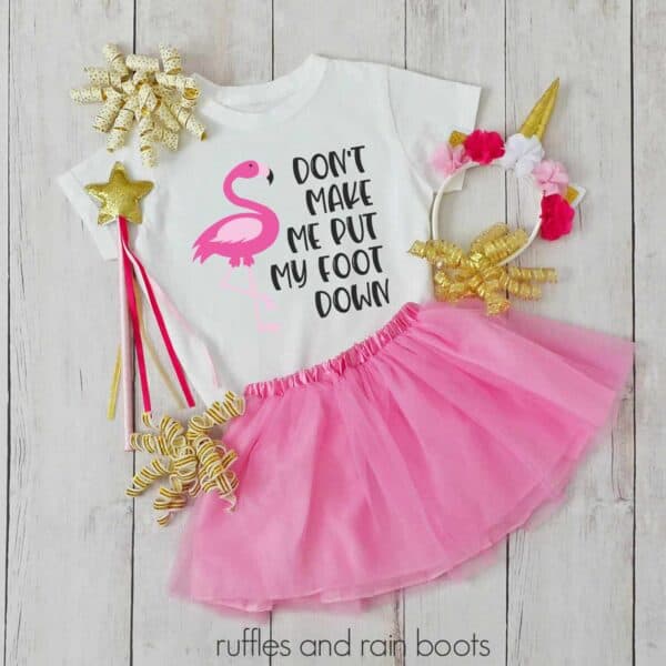 flamingo svg put my foot down on a kids shirt with tutu and accessories laying on a table