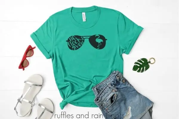 teal shirt surrounded by accessories on a table featuring a no flocks given flamingo svg in sunglasses cut out easy vinyl project