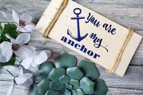 wood sign laying on a table featuring a you are my anchor cut file set to make coastal farmhouse crafts