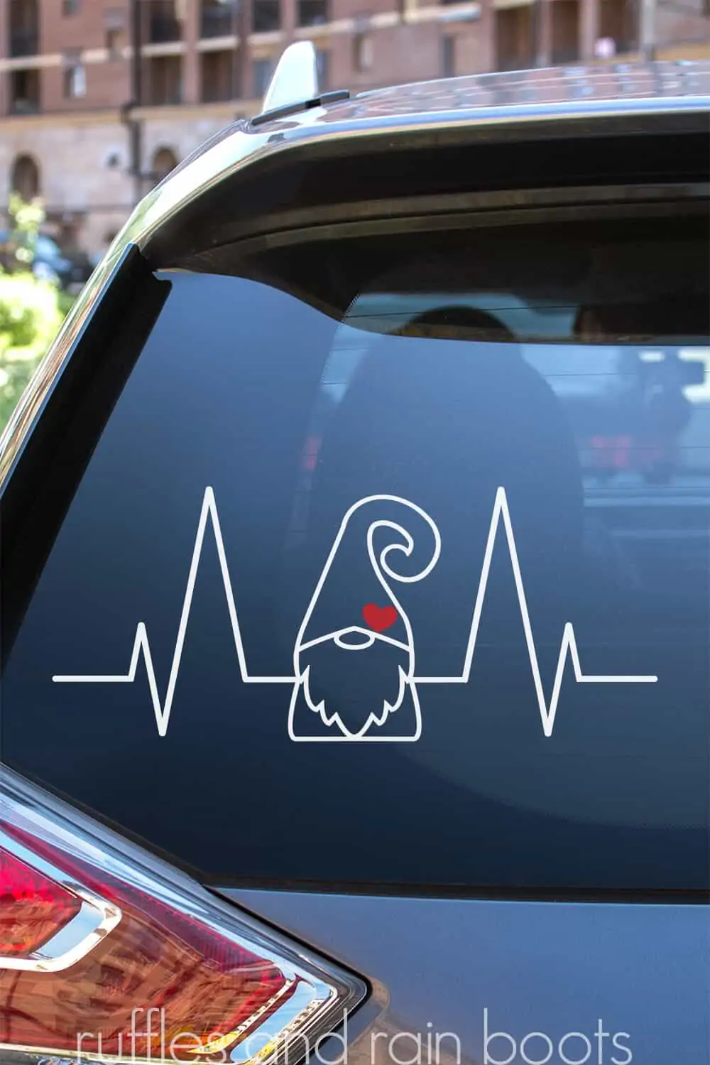vertical image of the back of a car window with a white gnome heartbeat design