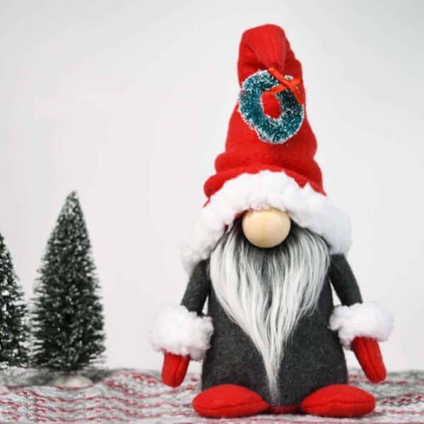 Christmas gnome pattern showing trim, red hat, gray body, Mongolian fur in frosted gray, and little trees on a holiday background and nordic print floor.