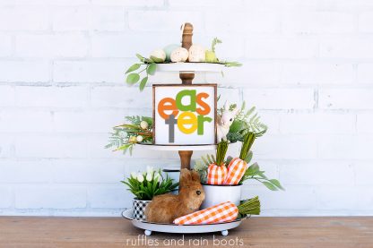 tiered tray on white background featuring Easter sign, bunny, fabric carrots, and greenery