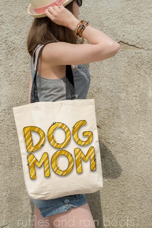 vertical image of woman with tote bag decorated with mustard and yellow animal print sublimation of dog mom