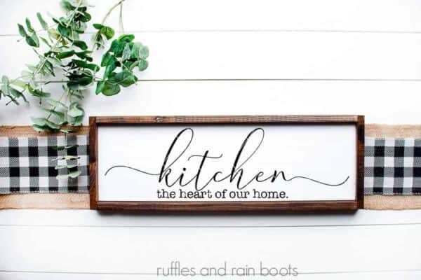 farmhouse kitchen svg on white wood background which reads kitchen in script and the heart of our home in typewriter font