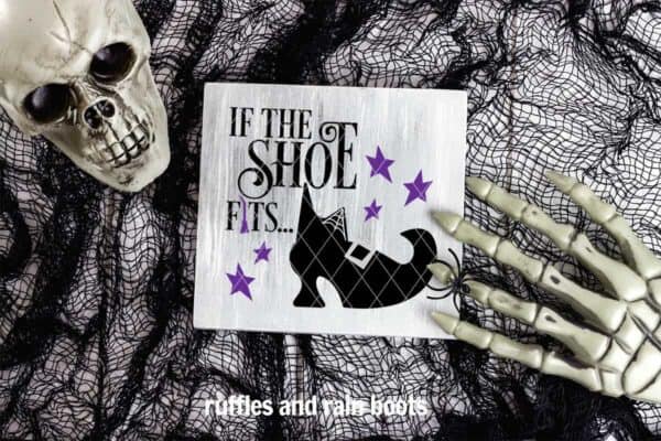 halloween image of black netting skull and skeleton hand over sign with if the shoe fits witch svg in black and purple
