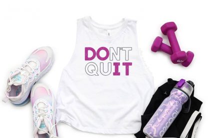 horizontal image of white tank with magenta and gray heat transfer vinyl applied with Cricut and heat press next to tennis shoes hand weights and water bottle