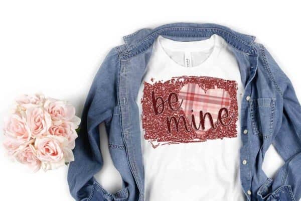 horizontal image of white background with pink roses and jean jacket with be mine sublimation for valentines day on white t shirt