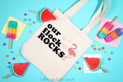 Horizontal image showing our flock rocks flamingo SVG on tote bag with bright color summer background.