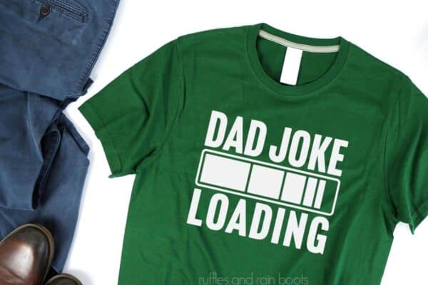 Horizontal image of free Dad Joke Loading SVG done in white vinyl on a dark green men's t-shirt for a father's day gift.