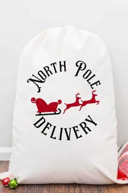 Vertical image of North Pole Delivery SVG with reindeer and sleigh in stamp style on Santa sack.