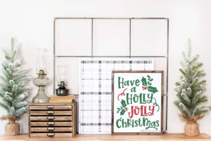 Horizontal image of a have a holly jolly Christmas SVG in red and green vinyl on white frame and farmhouse background.