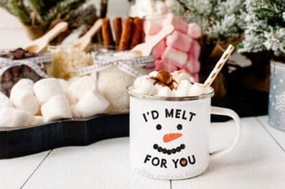 Horizontal image of a white camp mug with I'd melt for you in black and orange vinyl in front of a cocoa charcuterie board.