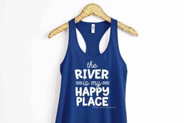 Horizontal image of a gold hanger and blue tank top with The River is My Happy Place in white heat transfer vinyl.