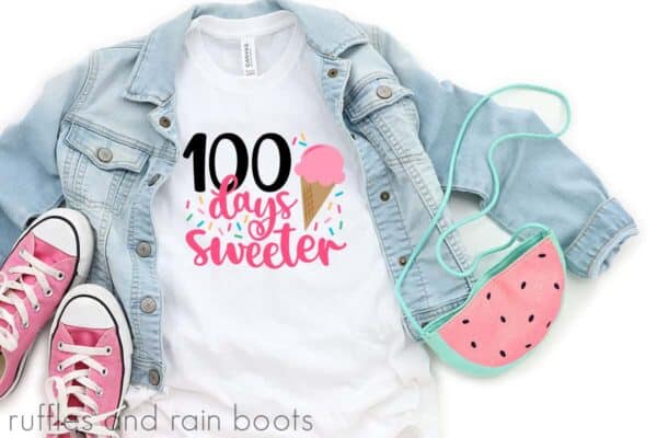 White t-shirt which reads 100 days sweeter with sprinkles and ice cream next to shoes and a purse.