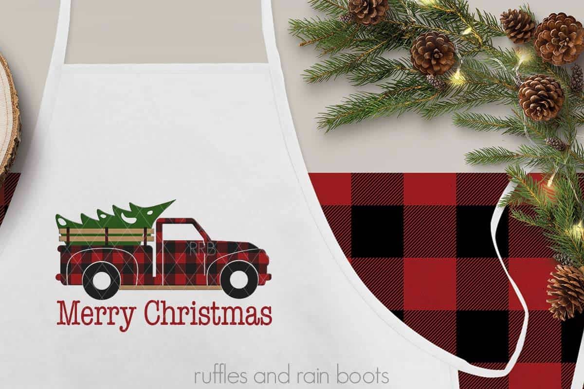 Horizontal close up image of white apron on holiday background with text which reads Merry Christmas under red plaid Christmas truck.