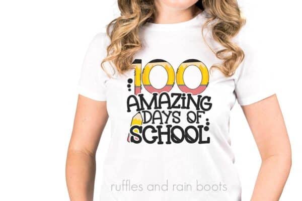 Woman in white t shirt wearing 100 amazing days of school design made with sublimation.