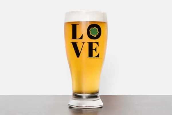 Horizontal image of beer mug on white background with black and green vinyl which reads LOVE with shamrock.