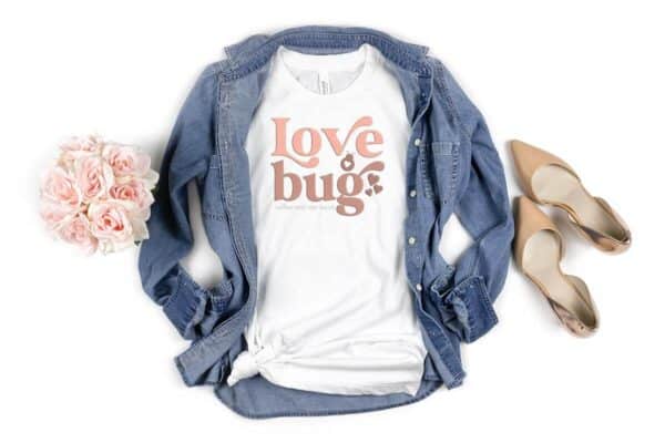 Horizontal image of white woman t shirt with love bug svg in retro style with hearts and jean shirt.