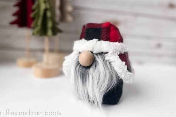 Horizontal image of close up gnome with a red patterned winter hat with ear flaps.