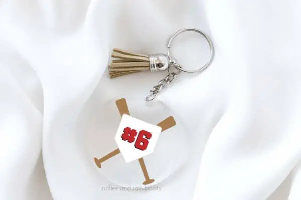 Horizontal image of clear acrylic keychain with baseball bats SVG and home plate with number.