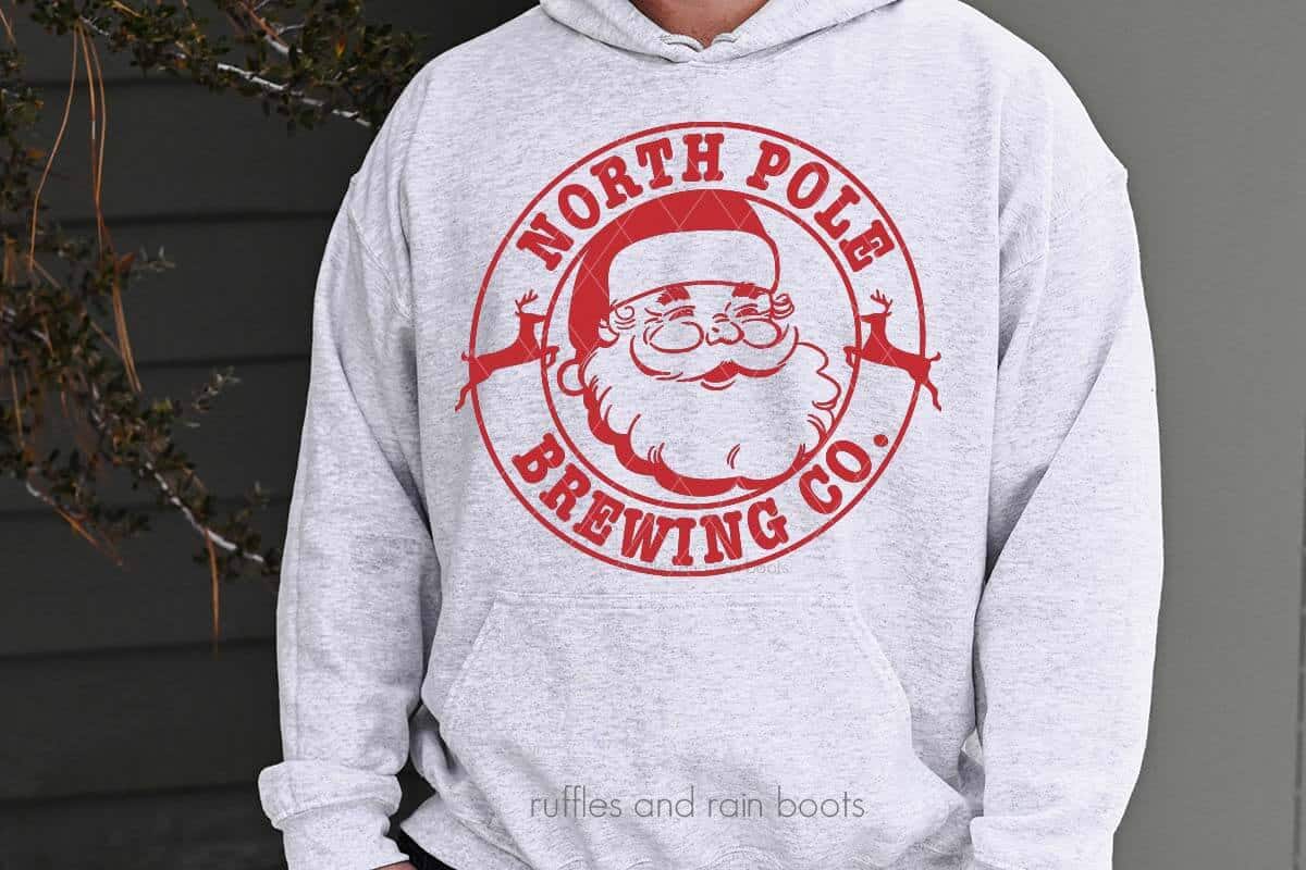 Horizontal image of Vintage Santa and North Pole Brewing SVG in red on heather gray sweatshirt.