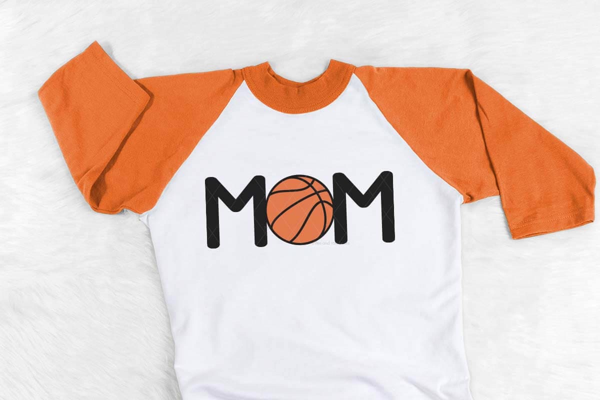 Horizontal image of white shirt with orange sleeves with a basketball Mom in heat transfer with text which reads basketball mom.