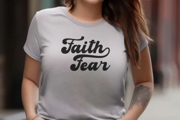 Horizontal image of a woman in a beige t shirt which reads faith over fear SVG.