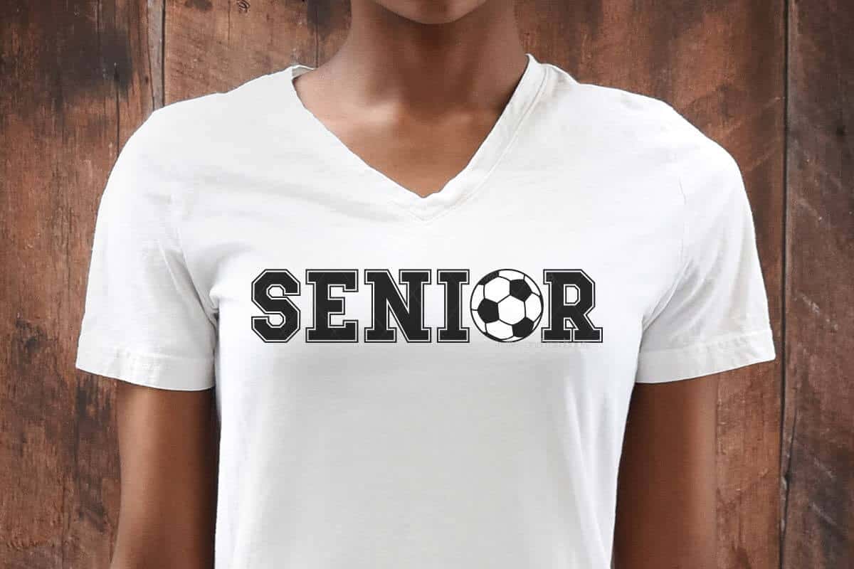 Horizontal image of a soccer player in front of a wood wall with a white t-shirt which reads Senior with a soccer ball SVG.