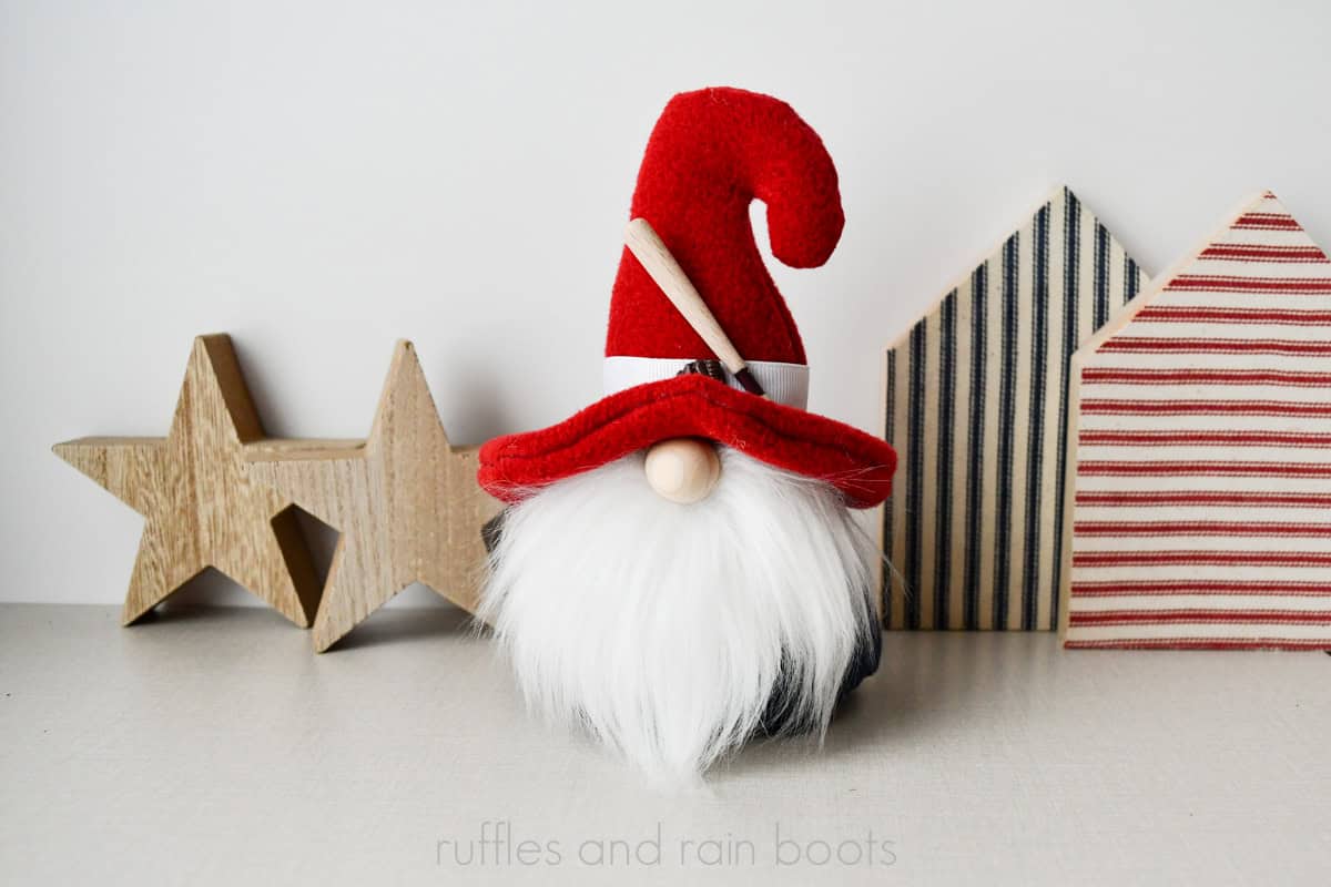 Baseball gnome with red hooked hat, blue body, white beard and patriotic background.