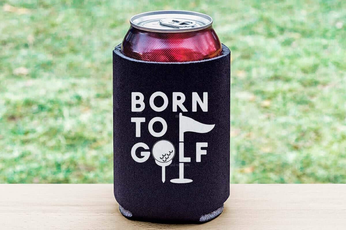 Horizontal image of a soda in a black can cooler with white vinyl which reads born to golf with a golf ball svg and a hole flag.