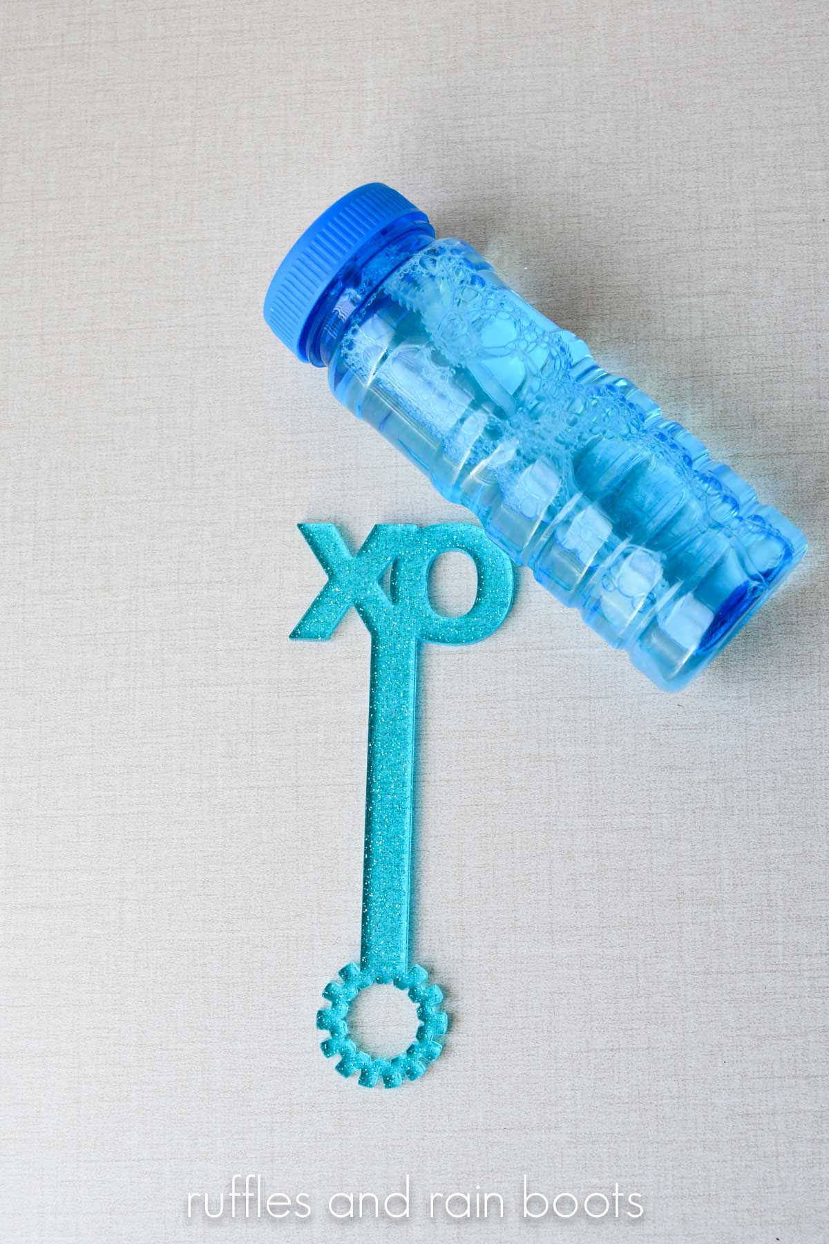 XO bubble wand for Valentine's Day with a blue jar of bubbles.
