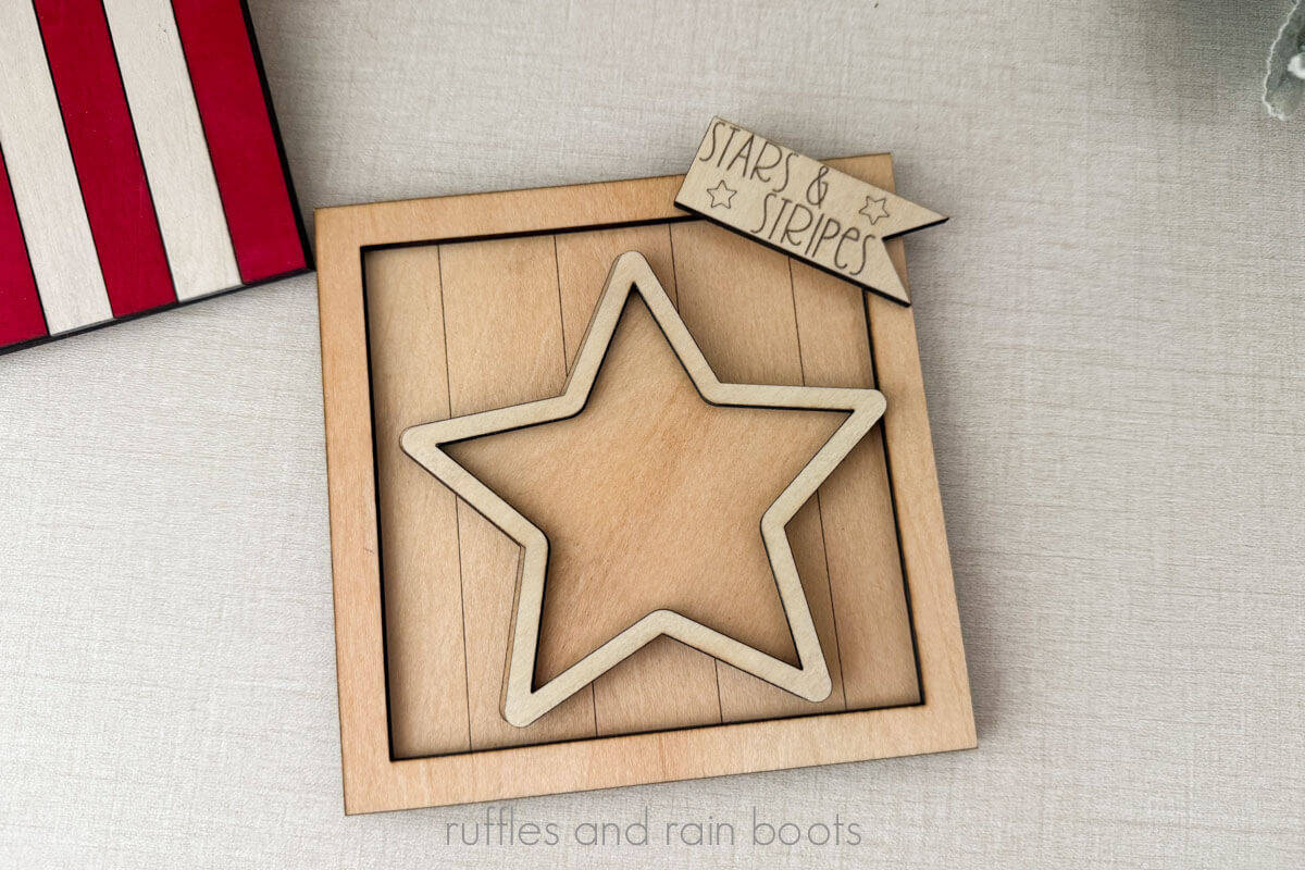 Horizontal image of a wood shelf sitter stacked with multiple layers of different woods in a 4th of July theme.